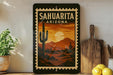 a framed poster of a desert landscape with a cactus and mountains in the background, placed on a shelf next to a wooden cutting board and some lemons.