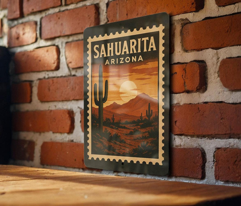 A metal sign with a desert landscape and a cactus is hanging on a brick wall.