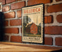 A vintage-style postage stamp featuring a red brick wall and a red brick building, with the text "BILLERICA MASSACHUSETTS U.S. POSTAGE" printed on it.