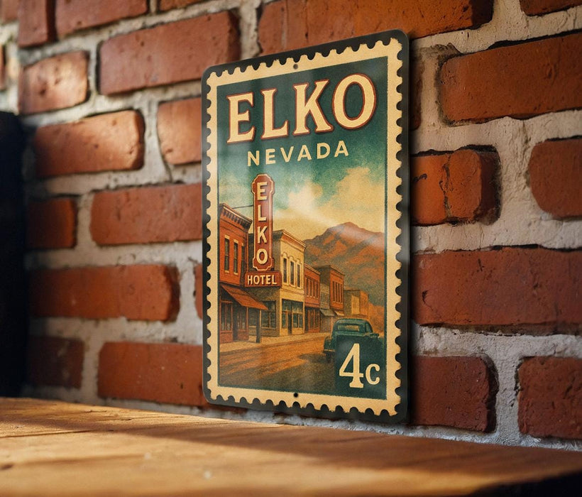 A vintage-style metal sign for Elko, Nevada, mounted on a brick wall.