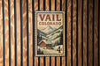 A vintage-style postage stamp from Colorado, featuring a snowy mountain landscape with a small cabin in the foreground.