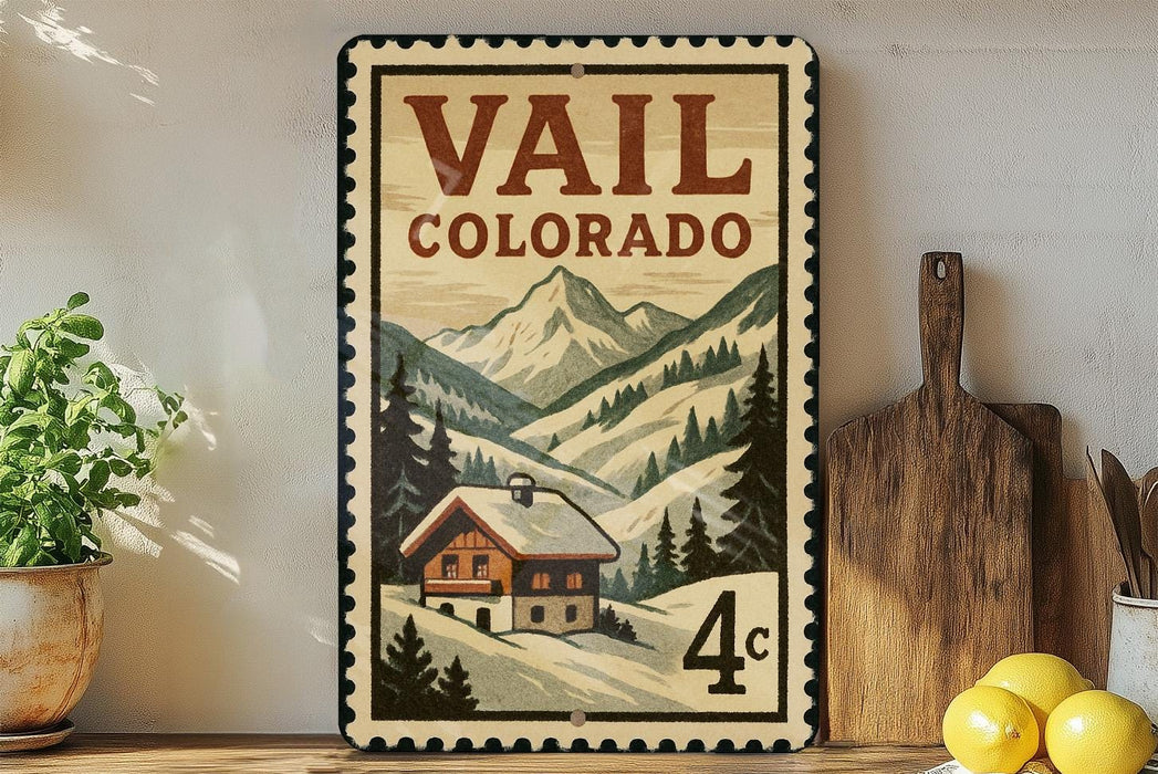 A vintage-style metal sign with a mountain landscape and a cabin, advertising "Vail, Colorado".