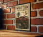 A vintage-style stamp depicting Whittier, California, with a palm tree and mountains in the background.