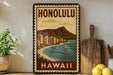 A vintage-style metal sign with the text "HONOLULU" and a picture of a beach and mountains, placed on a shelf next to a wooden cutting board and some potted plants.