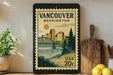A framed vintage postage stamp depicting the city of Vancouver, Washington, with a bridge and trees in the background.