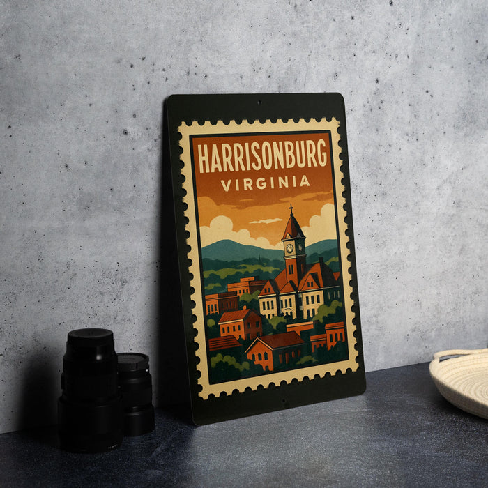 A framed vintage postage stamp depicting the town of Harrisonburg, Virginia, with a clock tower and colorful buildings.