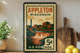 A vintage-style postage stamp from Wisconsin, featuring an illustration of a waterfall and buildings, displayed on a shelf next to a wooden cutting board and some lemons.