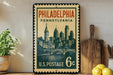 A vintage-style postage stamp from the United States Postal Service, featuring the Philadelphia skyline, is displayed on a shelf next to a wooden cutting board and some lemons.