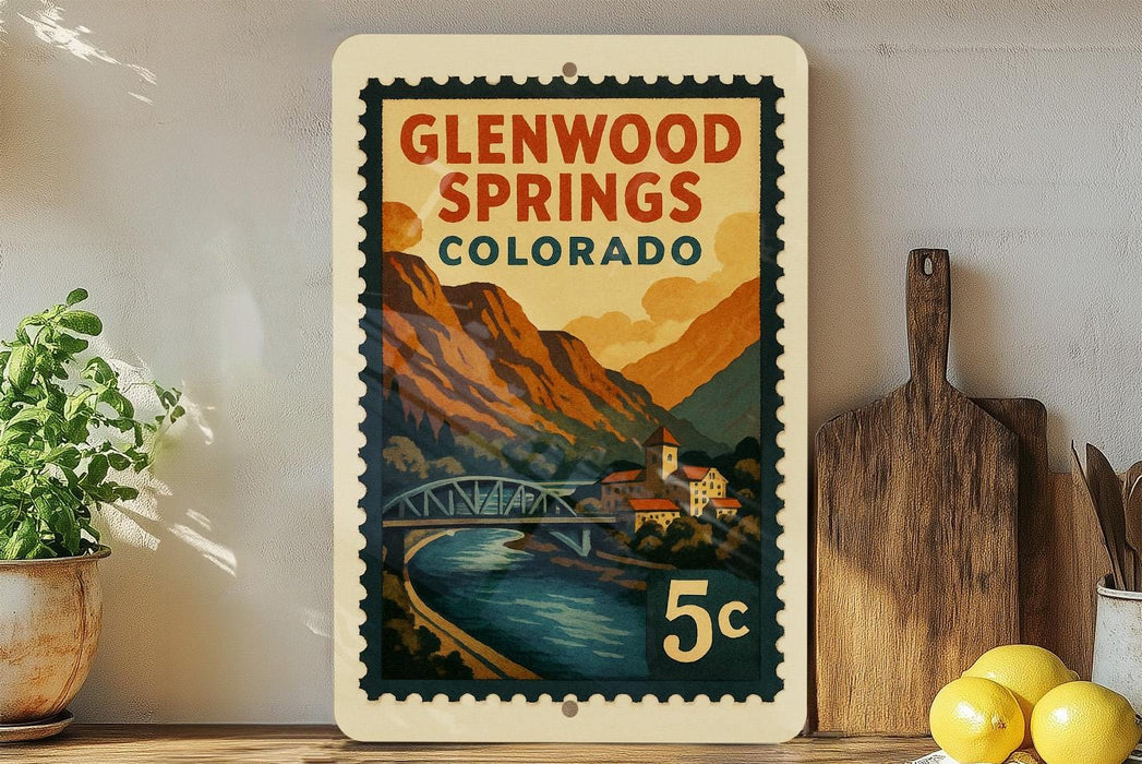 A vintage-style postage stamp depicting Glenwood Springs, Colorado, with a scenic mountain landscape and a bridge.