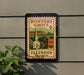 A vintage postage stamp from Illinois, featuring a church and buildings, is displayed on a wall.