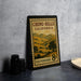 A vintage postage stamp from California, featuring a scenic landscape, is displayed on a table next to some black camera lenses.