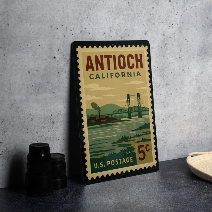 A vintage postage stamp from California, featuring a bridge and mountains, is displayed on a table.