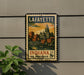 A vintage postage stamp from Lafayette, Indiana, featuring a cityscape and a bridge, is displayed on a wall.