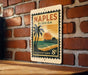 A vintage-style postage stamp from the United States of America, featuring a tropical beach scene with palm trees and a sunset.