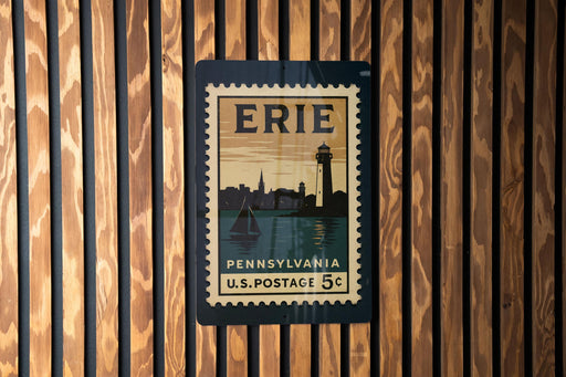 A vintage-style postage stamp from the United States, featuring the city of Erie, Pennsylvania, with a lighthouse and a sailboat in the background.