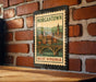 A vintage-style metal stamp depicting a cityscape with a bridge, mounted on a brick wall.