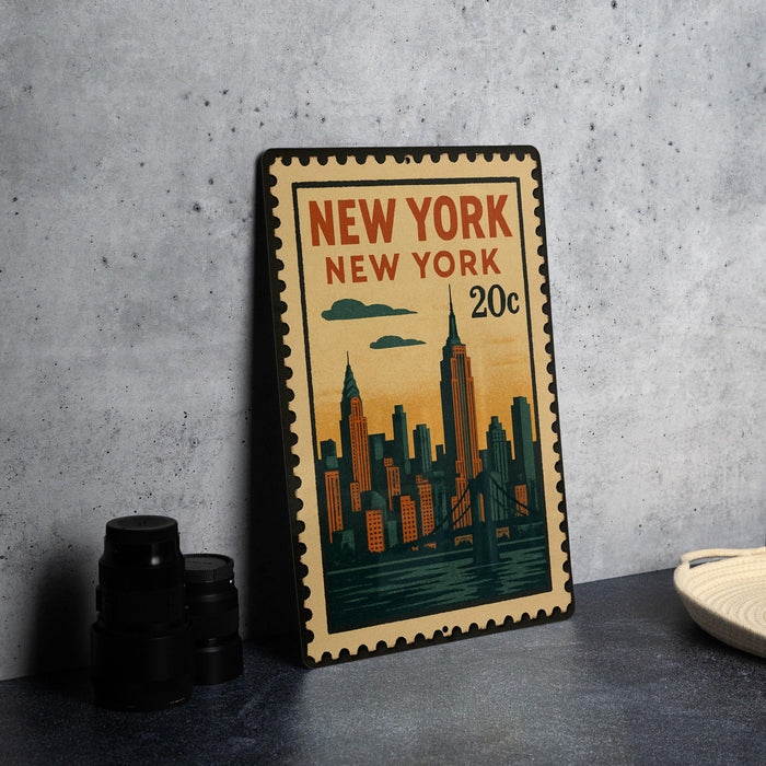A vintage-style metal stamp depicting the New York City skyline, with the text "NEW YORK NEW YORK 20c" printed on it.