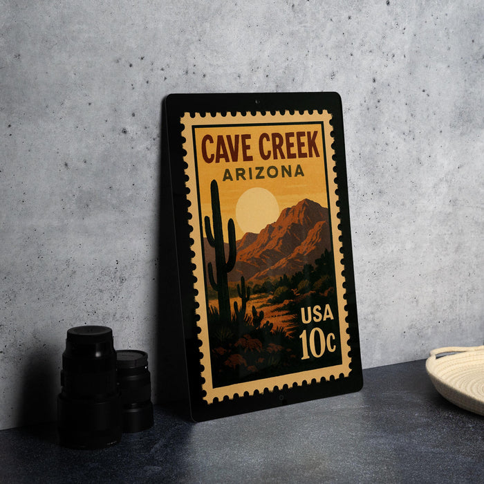 A framed poster of a desert landscape with a cactus and mountains, featuring the text "CAVE CREEK ARIZONA" and "USA 10c" printed on it.