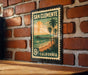 A vintage-style postage stamp from San Clemente, California, featuring a beach scene with palm trees and a pier.