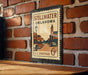 A vintage-style postage stamp from Stillwater, Oklahoma, featuring a street scene and a church, mounted on a brick wall.