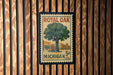 A vintage-style postage stamp from Michigan, featuring a tree and a store, is displayed on a wooden wall.