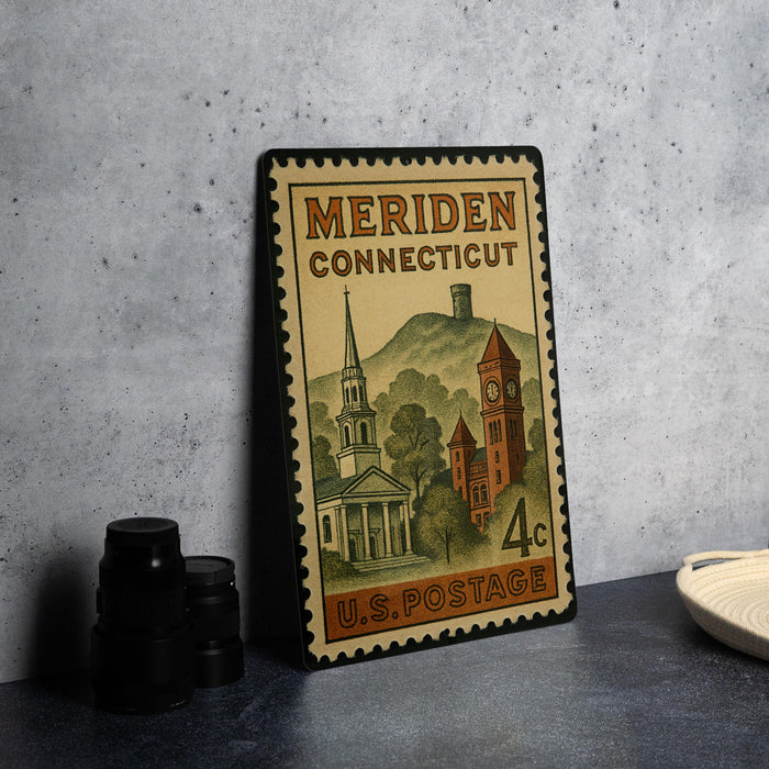 A vintage postage stamp from Connecticut, featuring a church and other architectural elements, is displayed on a table.