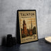 A vintage Massachusetts postage stamp featuring a clock tower and other architectural elements, placed on a countertop next to some camera equipment.
