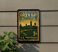 A vintage postage stamp from Wisconsin, featuring a cityscape and a river, is displayed on a wall.