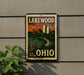 A vintage-style postage stamp from the United States, featuring an illustration of Lakewood, Ohio, with a cityscape and a river in the background.
