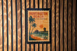 A postage stamp depicting Huntington Beach, California, with a beach scene and palm trees.