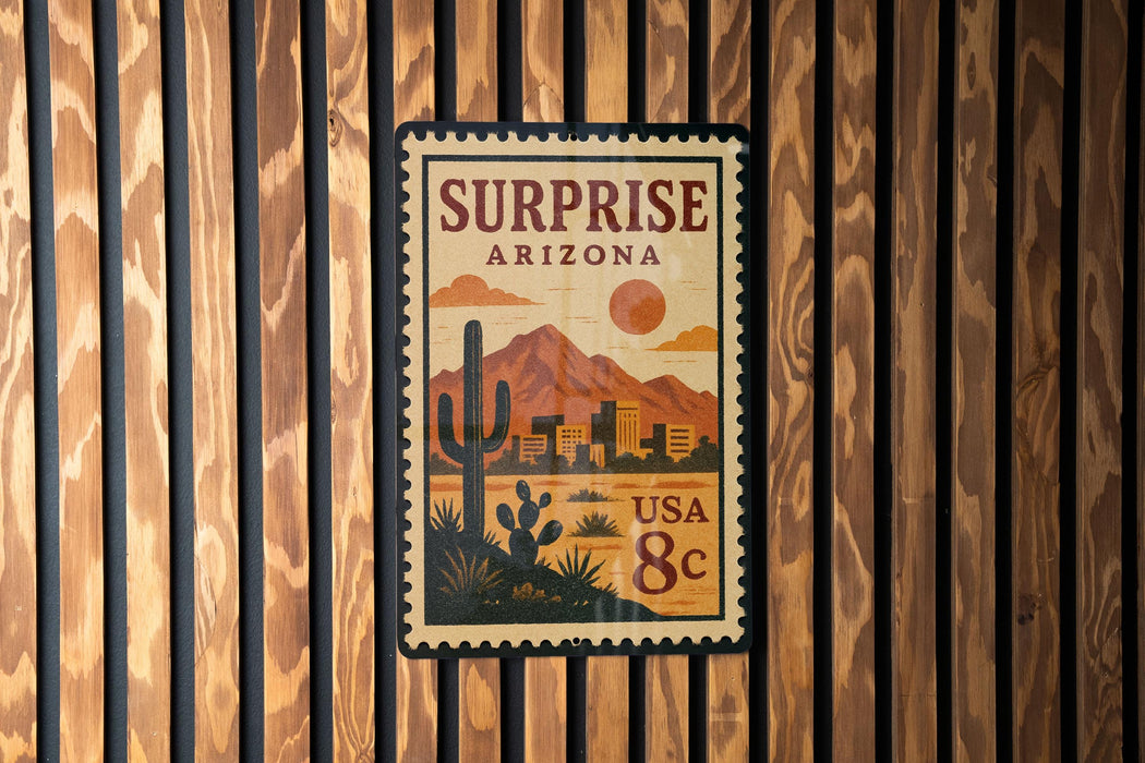 A vintage-style postage stamp from Surprise, Arizona, featuring a desert landscape with mountains and a cactus in the center.