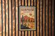 A vintage-style postage stamp from Surprise, Arizona, featuring a desert landscape with mountains and a cactus in the center.