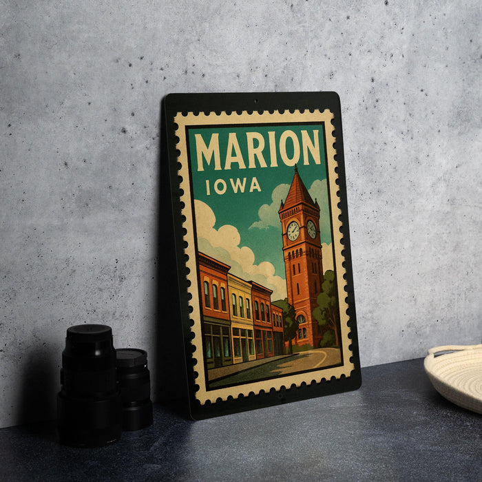 A framed vintage postage stamp depicting a cityscape with a clock tower, placed on a countertop next to some black camera lenses.