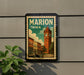 A vintage-style postage stamp depicting a cityscape with a clock tower, mounted on a wall next to a plant.