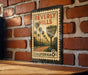 A vintage-style metal sign with the text "BEVERLY HILLS" and "BEVERLY HILLS" displayed on it, mounted on a brick wall.