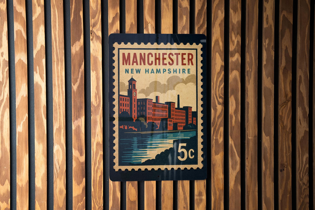 A vintage-style postage stamp from Manchester, New Hampshire, featuring a cityscape and a river.