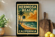 A vintage-style metal sign with the text "HERMOSA BEACH CALIFORNIA" and a beach scene with palm trees and a pier.