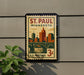 A vintage postage stamp from Minnesota, featuring a cityscape and a bridge, is displayed on a wall.