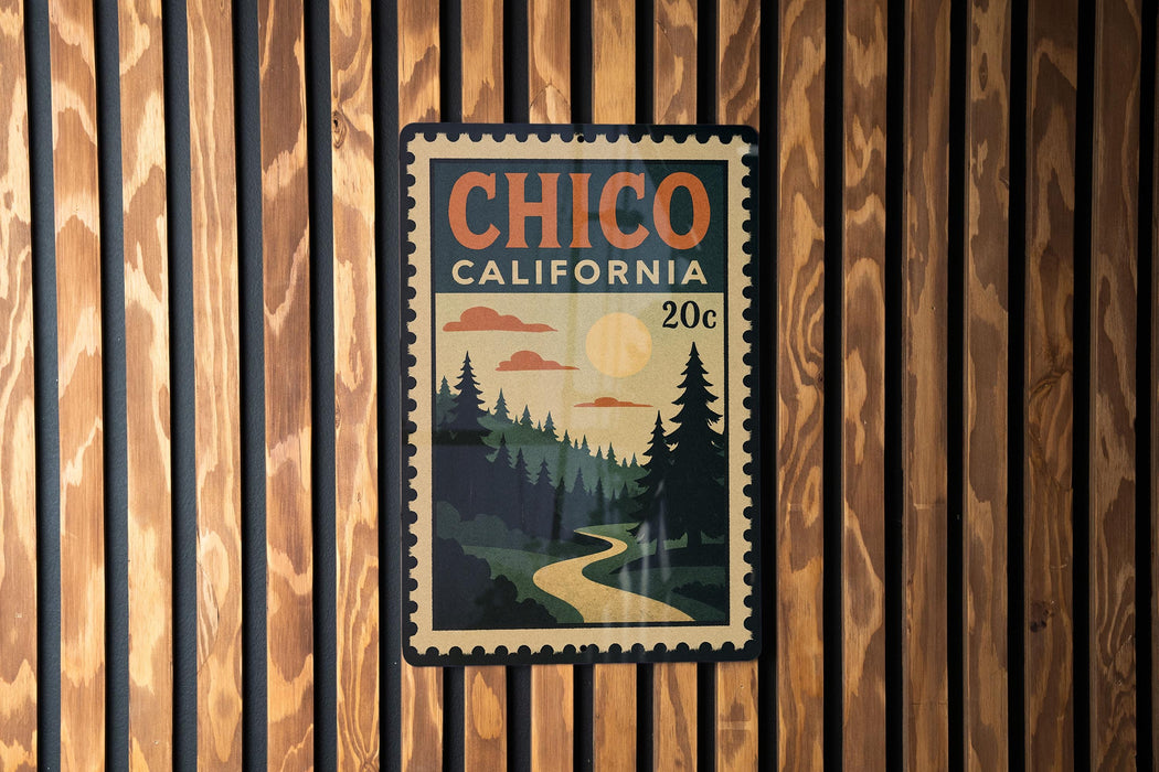 A vintage-style postage stamp from California, featuring a scenic landscape with pine trees, a winding road, and a sunlit sky.