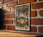 A vintage-style postage stamp from South Gate, California, featuring a street scene and palm trees.