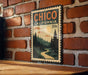 A vintage-style metal sign with the text "CHICO CALIFORNIA" and a landscape illustration, mounted on a brick wall.