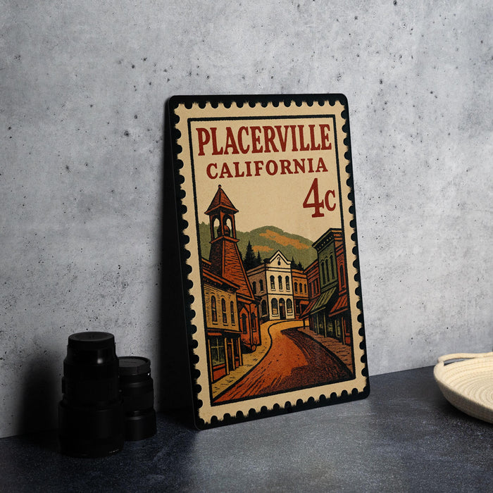 A framed illustration of a small town in California, featuring a street, buildings, and a bell tower, is displayed on a table.