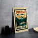 a sign that reads "Juneau Alaska" with a mountain landscape and a boat in the background.