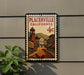 A vintage-style metal sign with a postage stamp design, mounted on a wall.