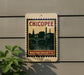 A vintage-style sign for Chicopee, Massachusetts, featuring a cityscape and a bridge.