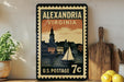 A vintage-style postage stamp from the United States, featuring an illustration of a sailboat on a body of water with a cityscape in the background.
