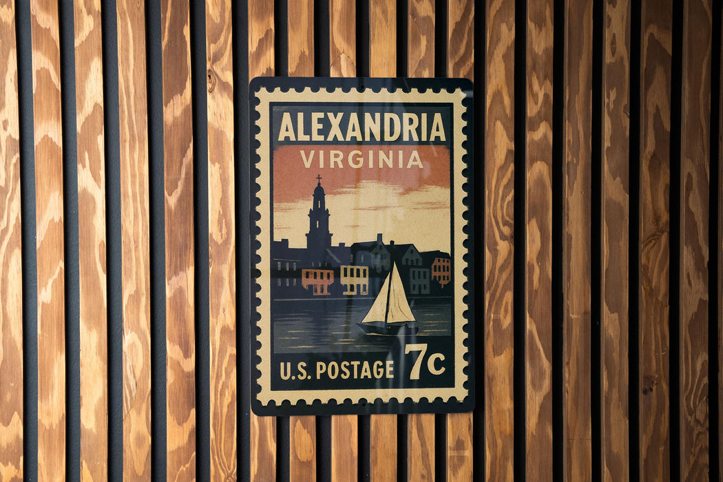 A vintage-style postage stamp from the United States, featuring the city of Alexandria, Virginia, with a sailboat and a building in the background.