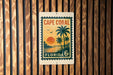 A vintage-style stamp or sign for Cape Coral, Florida, featuring a palm tree and sunset landscape.