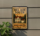 A metal sign with the text "BEL AIR SOUTH" and "MARYLAND 15¢" is displayed on a wall, with a plant to the left of the sign.