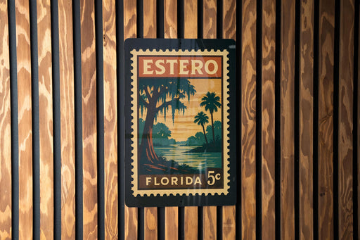 A vintage-style postage stamp from Florida, featuring a tropical landscape with palm trees and a body of water, is displayed on a wooden wall.